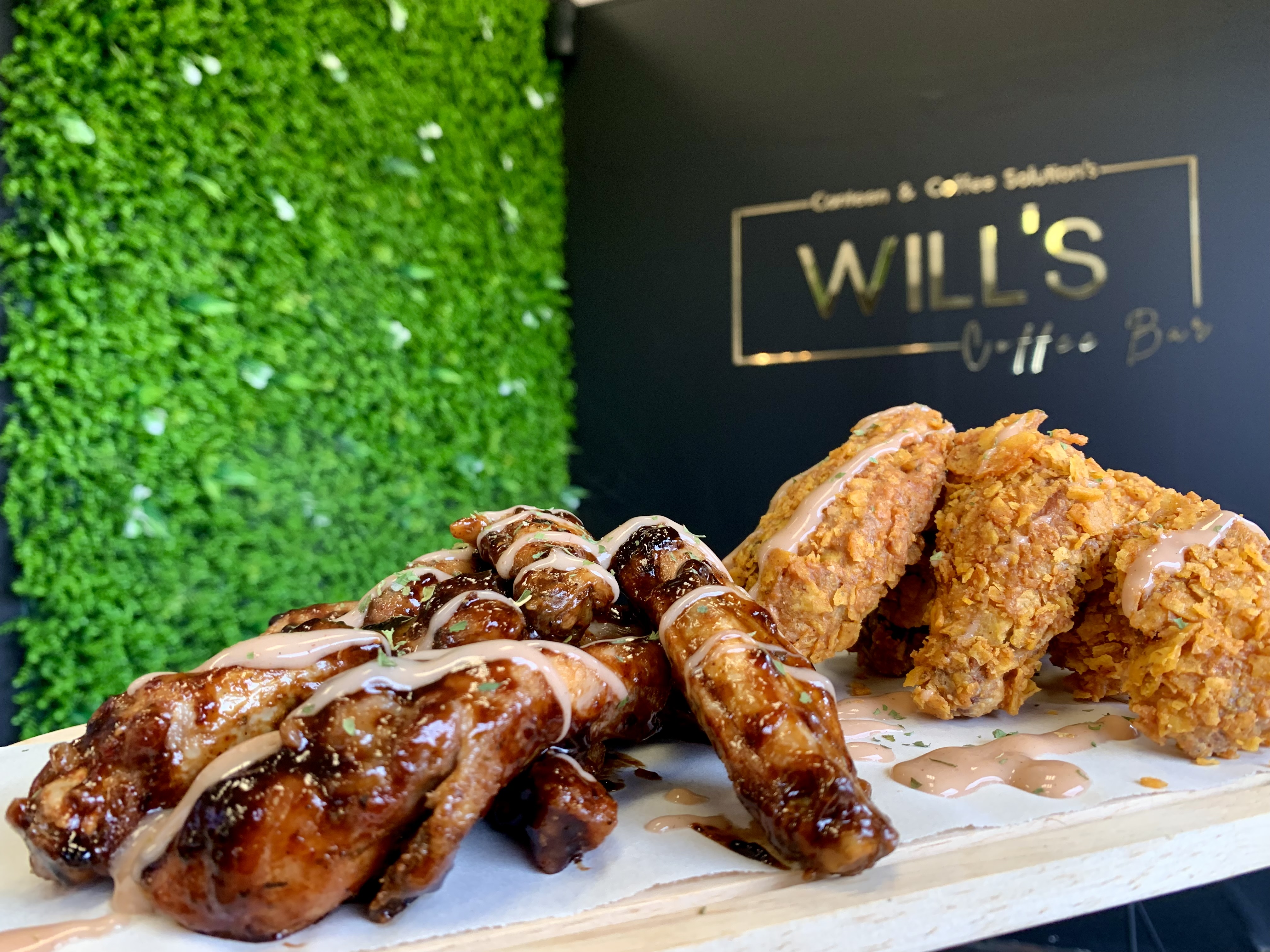 Glazed and crispy chicken wings plated at the Will's Coffee Bar counter